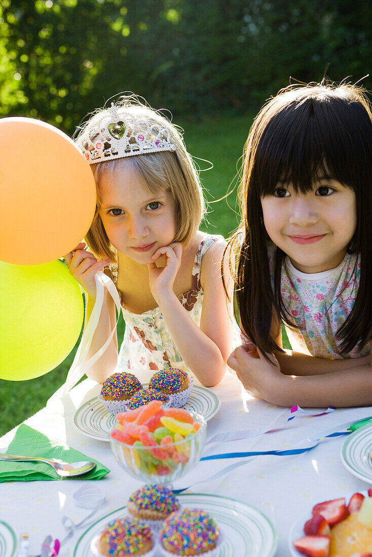 Girls admiring sweets table at outdoor party