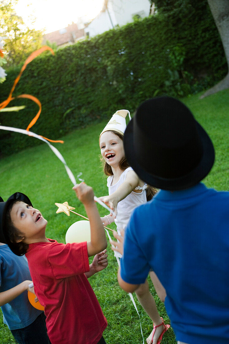 Children pulling streamers attached to pull string pinata