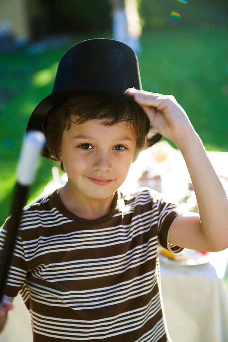 Boy with magic wand and magician's hat, portrait