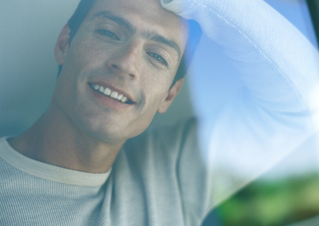 Man smiling, seen through window