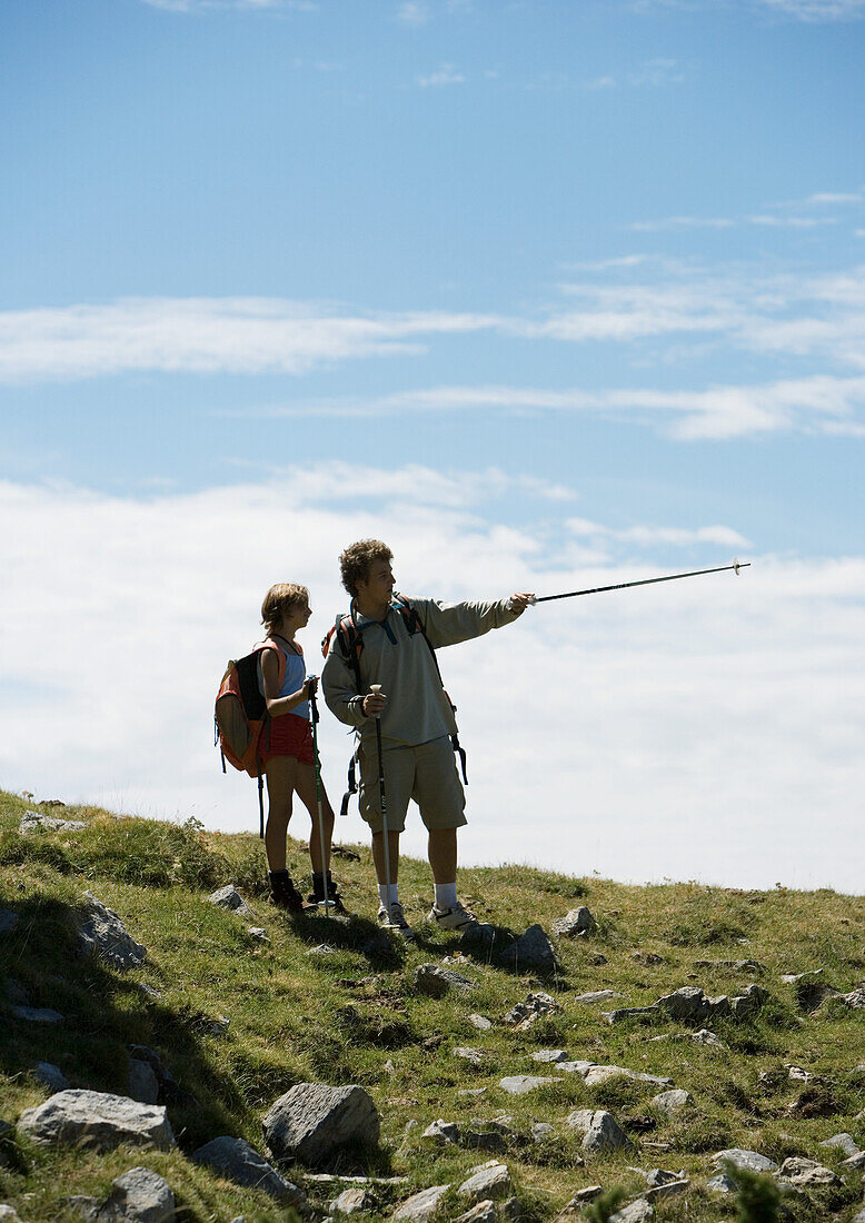 Hikers, man pointing with walking stick