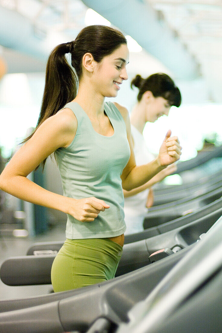 Two women running on treadmills