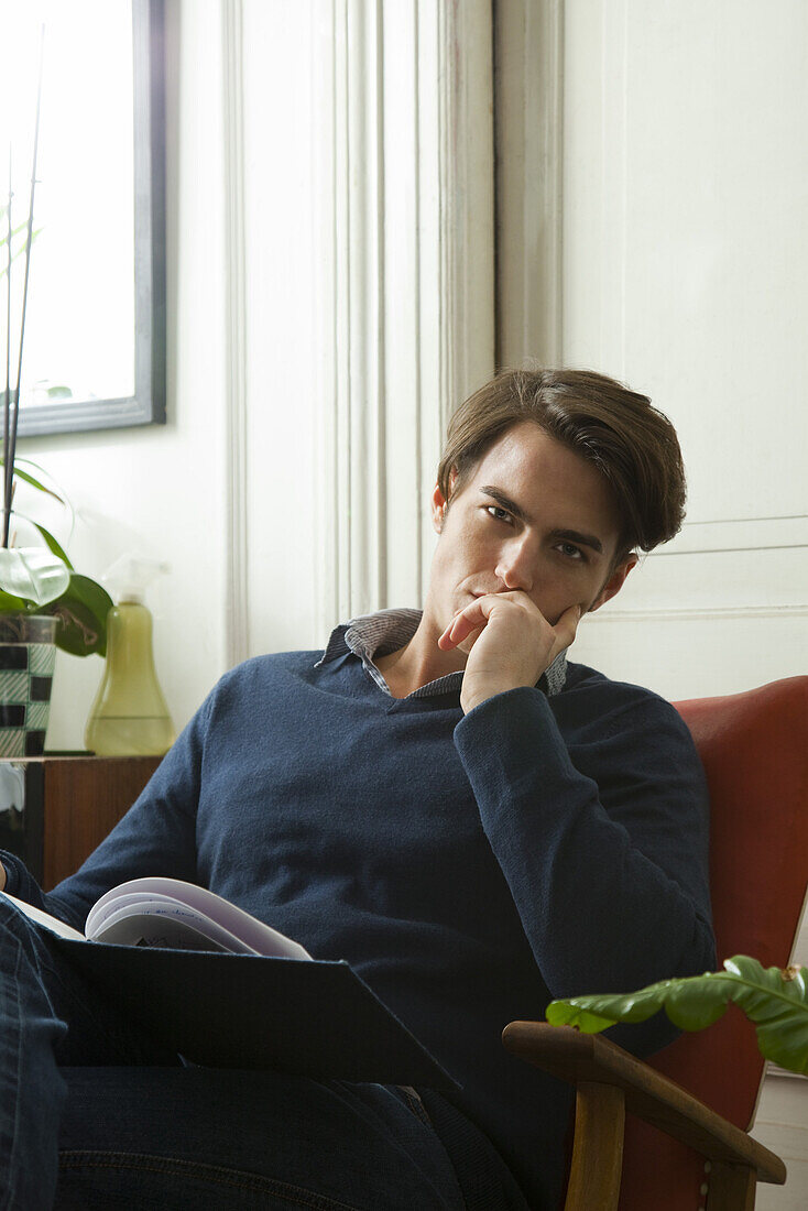Man sitting with book on lap, portrait