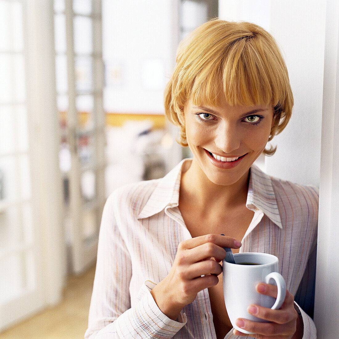 Teen girl leaning against wall, holding mug, portrait