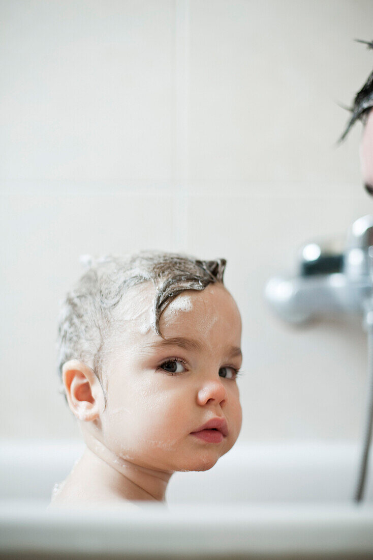 Toddler boy taking a bath, portrait