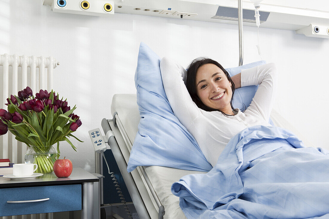 A cheerful patient lying in a hospital bed