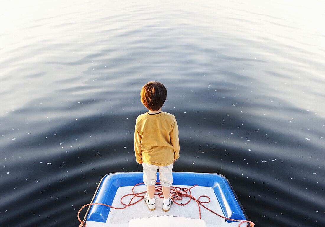A boy standing at the edge of a floating jetty