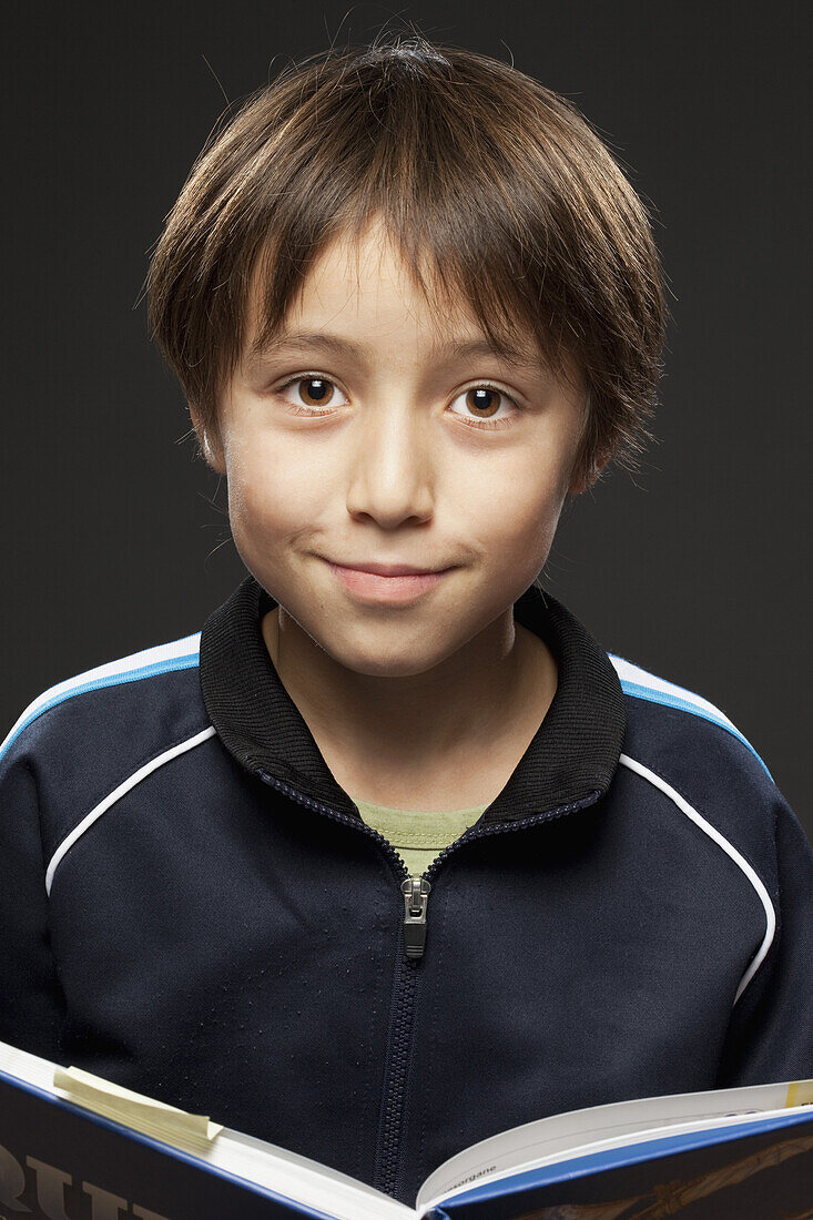 Portrait of a boy holding an open book