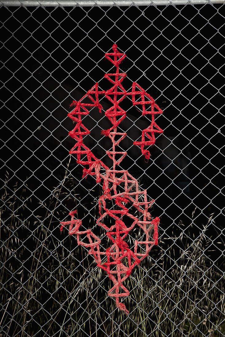 Dollar sign design on a chain link fence