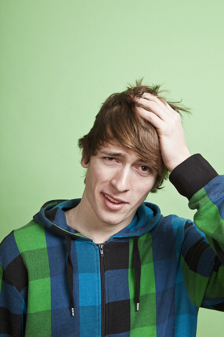 A teenage boy looking embarrassed, portrait, studio shot