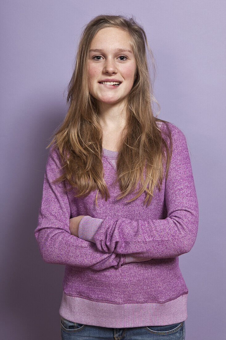 A teenage girl biting her lip, portrait, studio shot