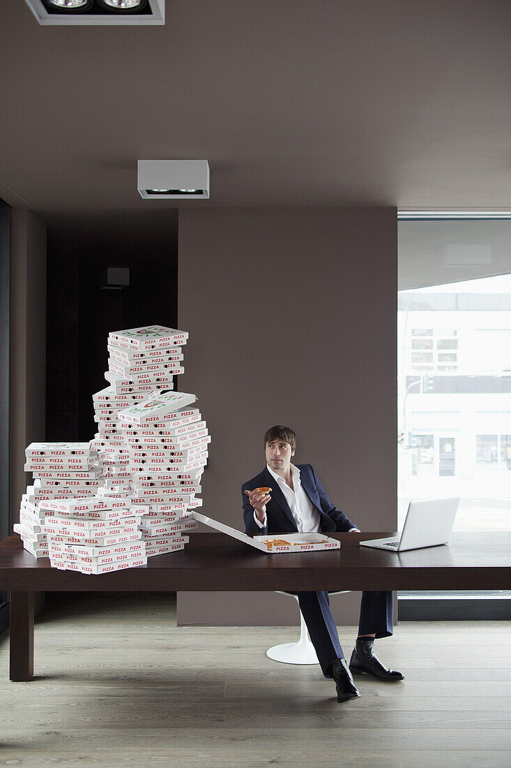 Many pizzas on table for businessman working at home.