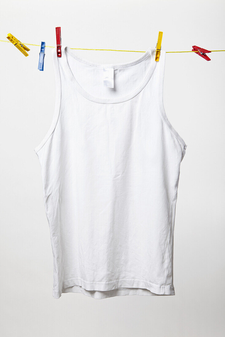 White tank top hanging on clothes line
