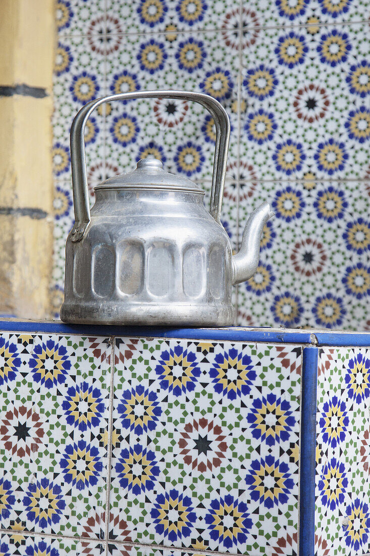 Old tea kettle on tiled counter