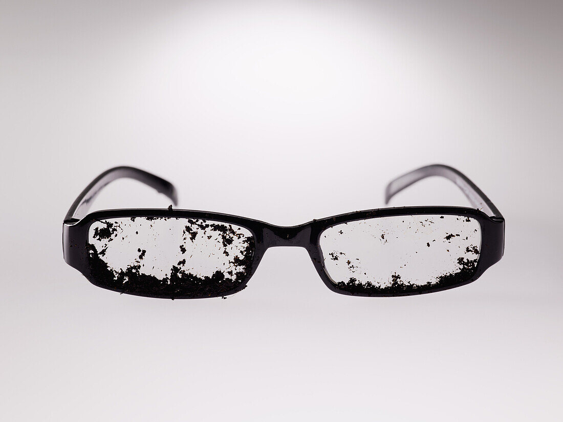 Dirty eyeglasses over gray background