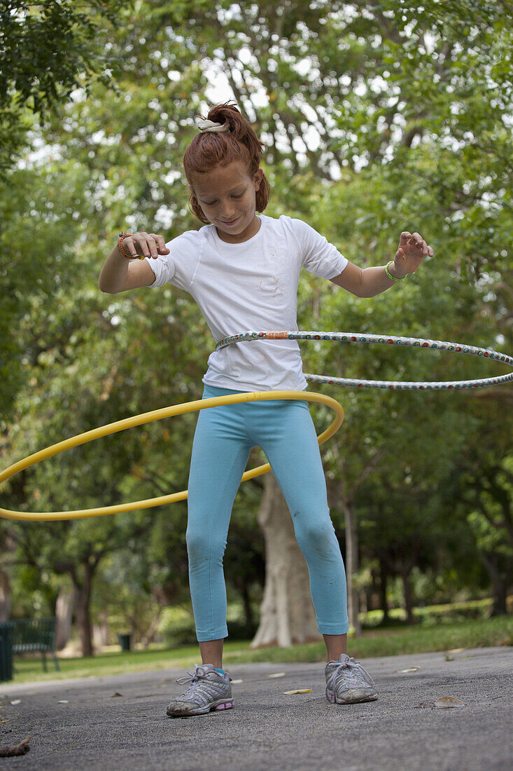 Girl with hula hoops in park