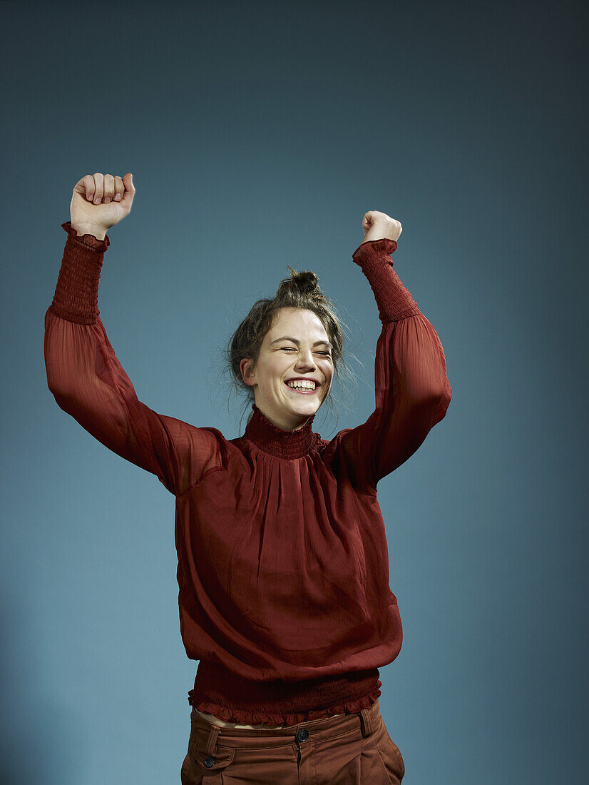 A young hip woman with her arms raised in celebration