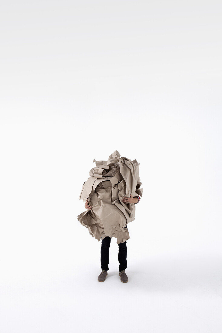 A man carrying an impossibly large ball of crumpled construction paper