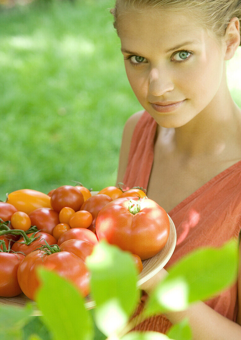 Woman holding bowl full of tomatoes