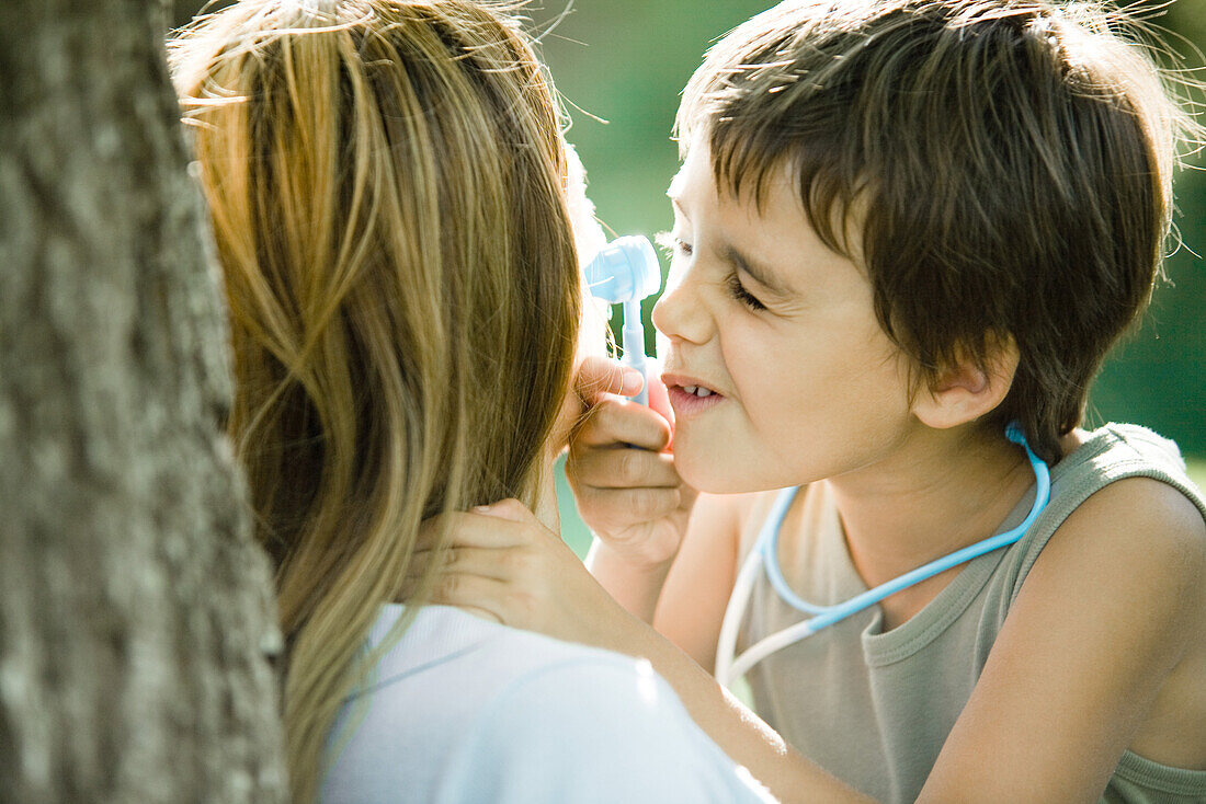 Mother and son, boy pretending to be doctor