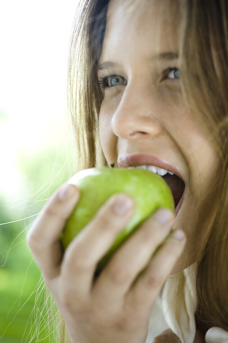 Young woman eating green apple