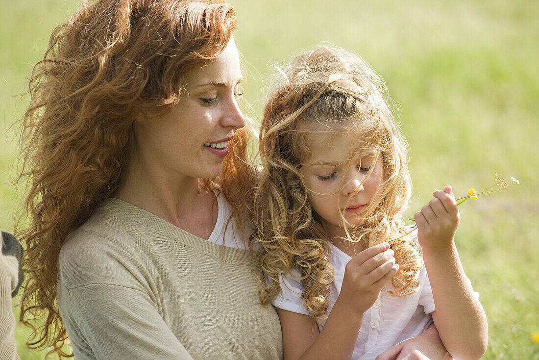 Mother and young daughter relaxing together outdoors