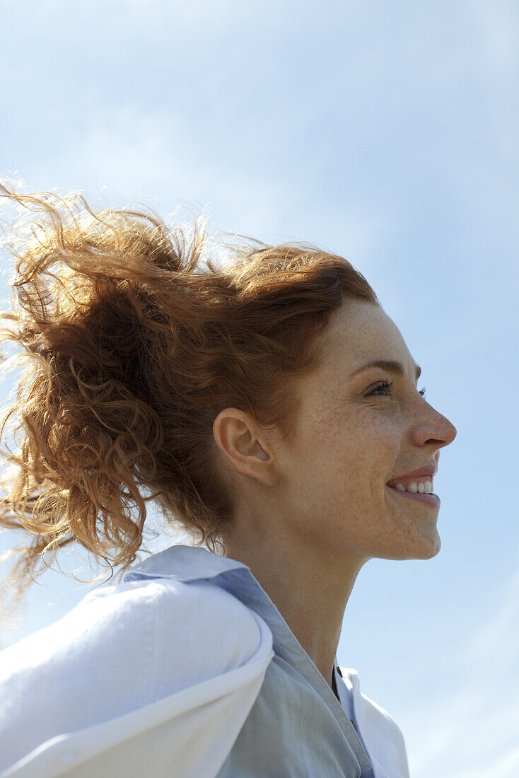 Woman smiling outdoors, profile