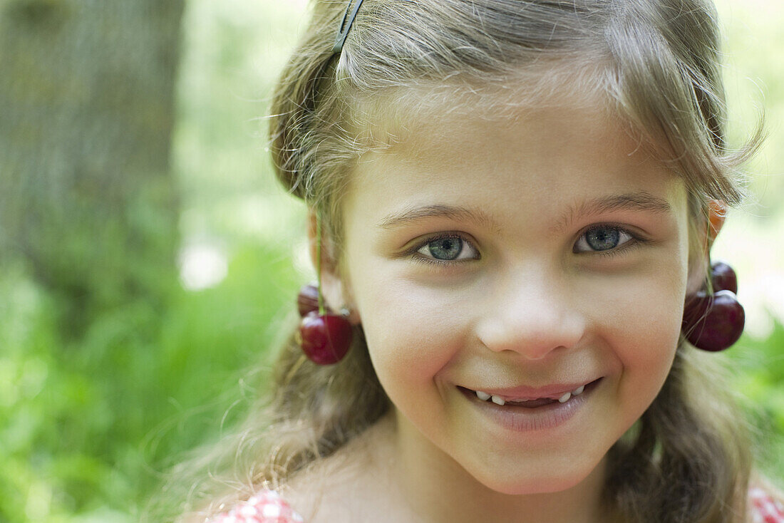 Girl with cherries dangling from her ears, portrait