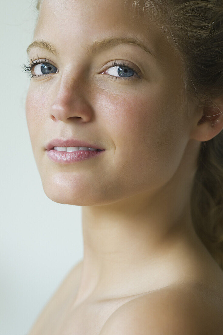 Young woman looking over shoulder at camera, portrait