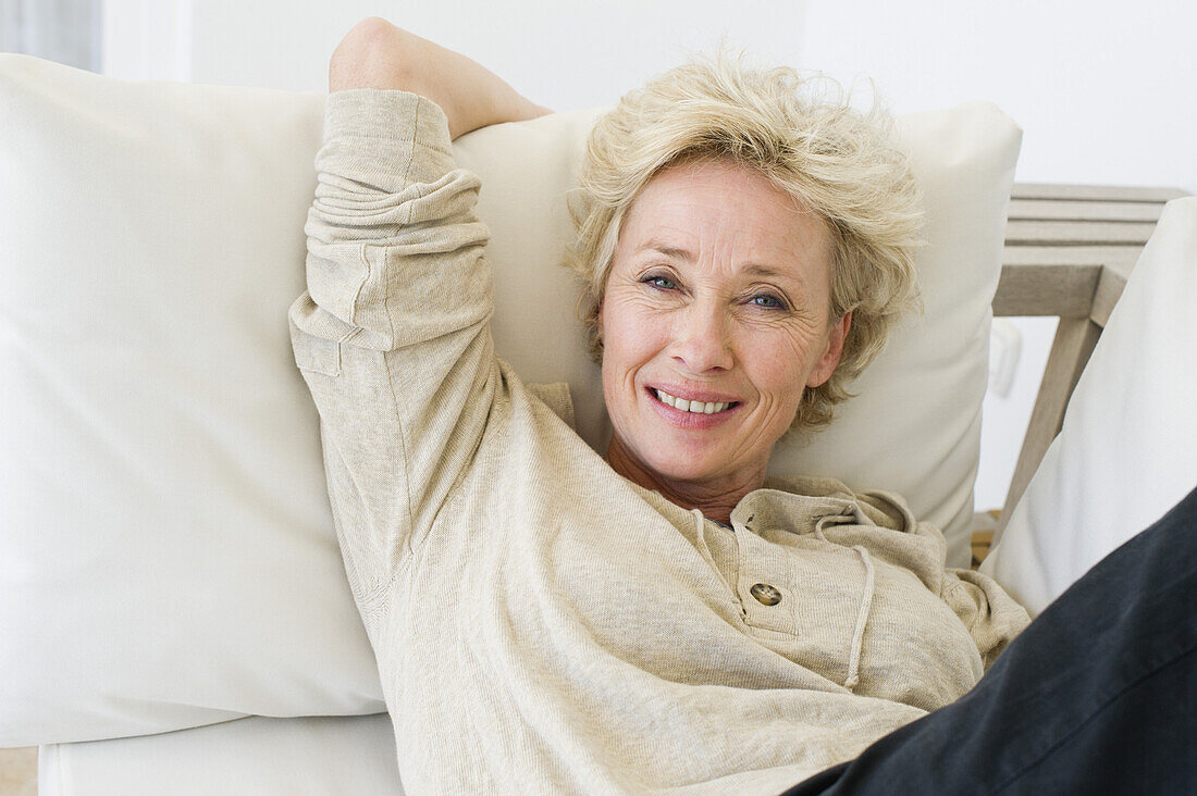 Mature woman relaxing on sofa, portrait