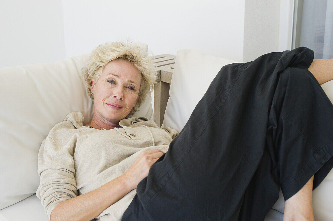 Mature woman reclining on sofa