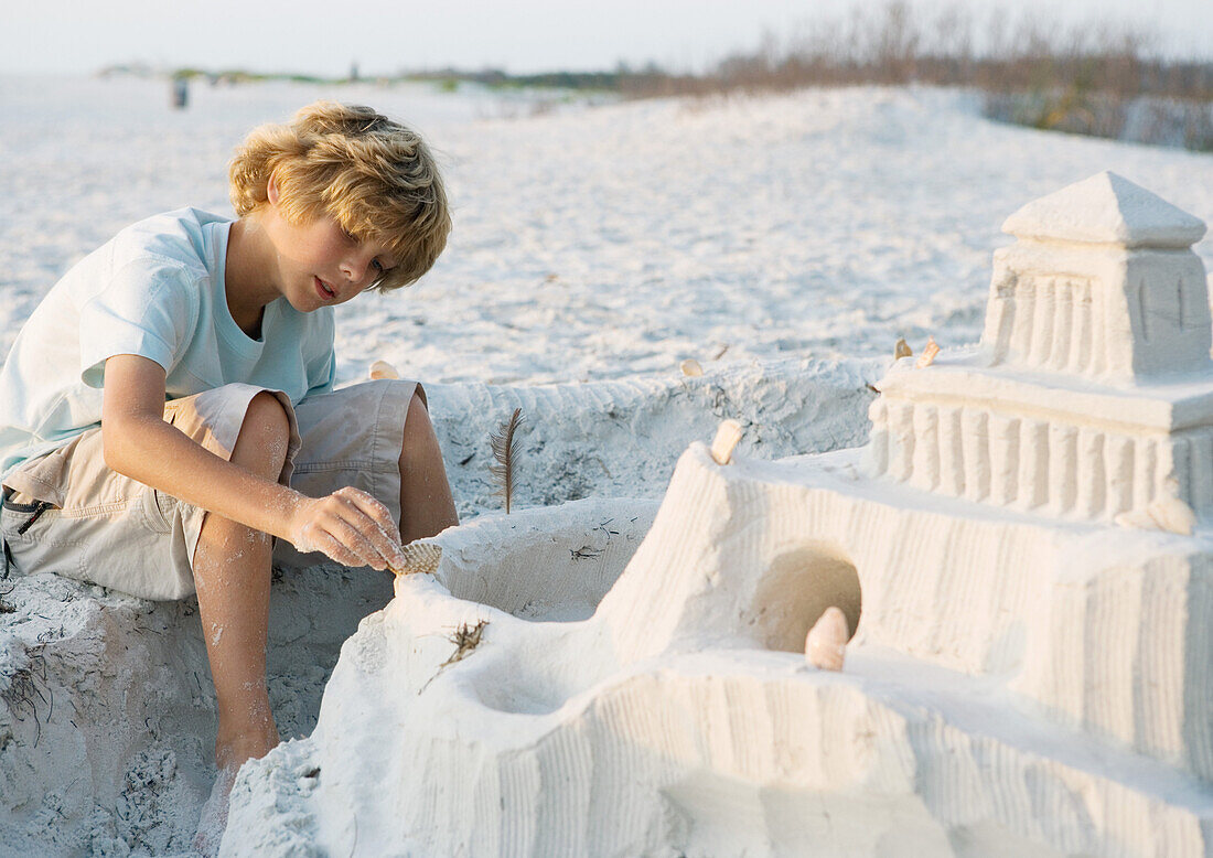 Boy putting finishing touches on sand castle