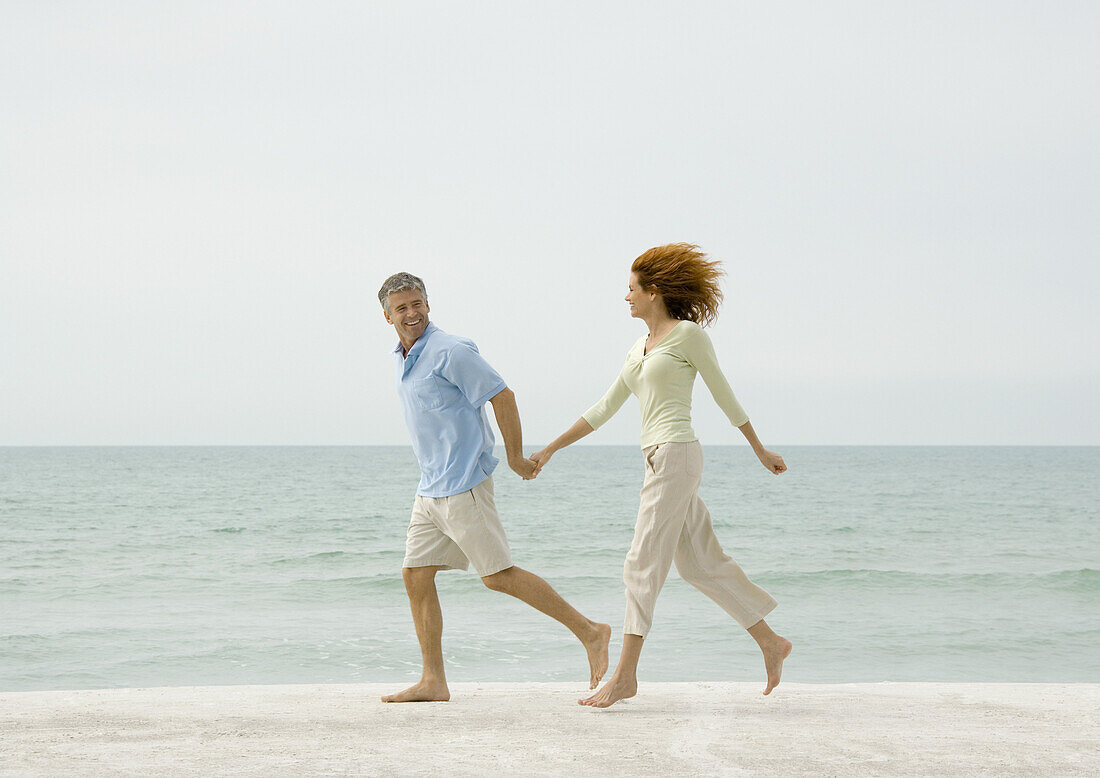 Mature couple running on beach