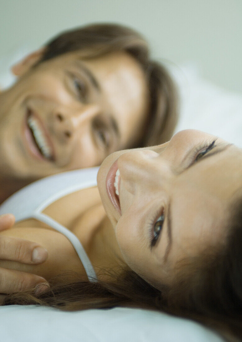 Couple lying in bed together, smiling