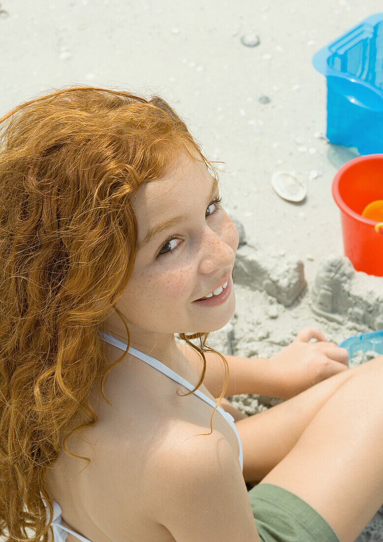 Girl playing in sand on beach