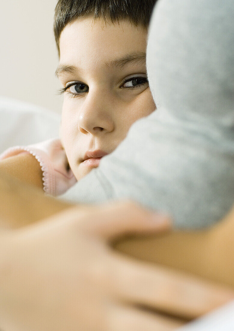 Child with arm around mother