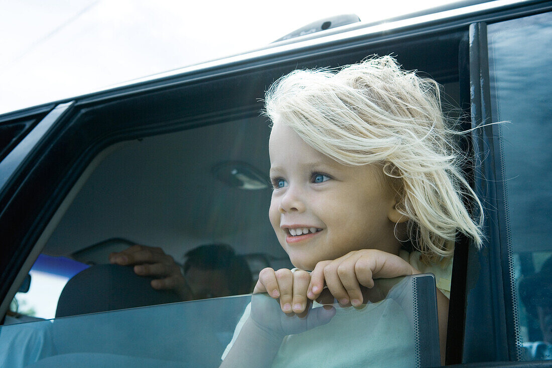 Child sticking head out of car window
