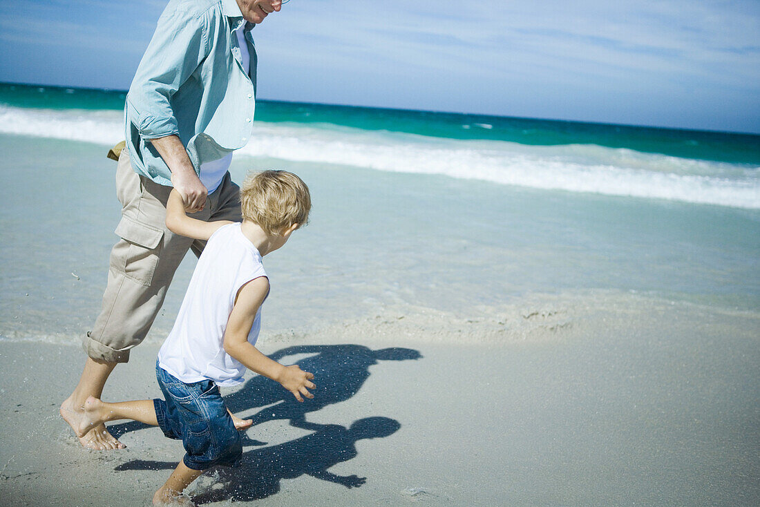 Man and boy walking on beach