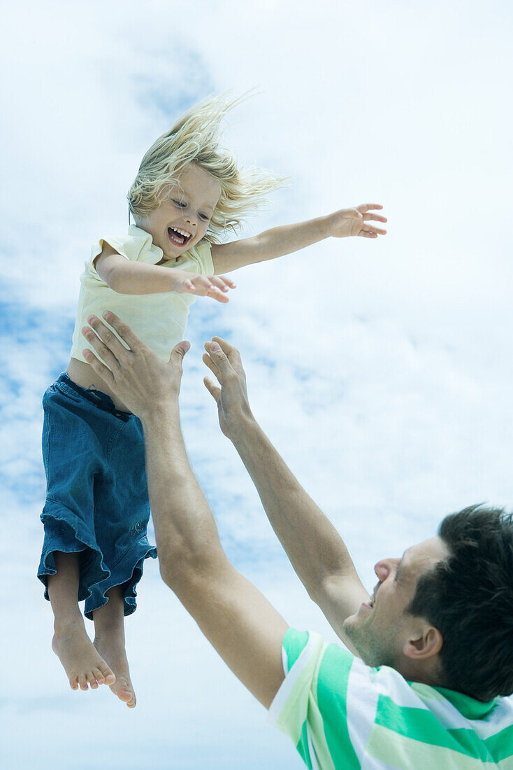Man throwing child into air