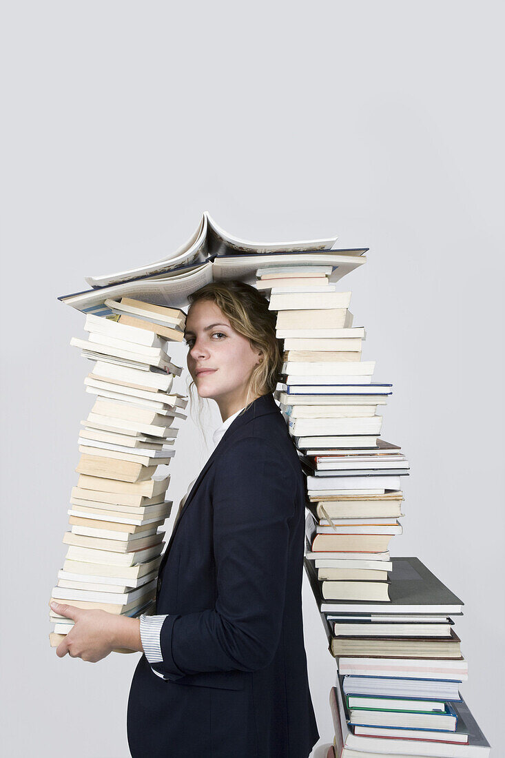 Woman surrounded by books looking at camera