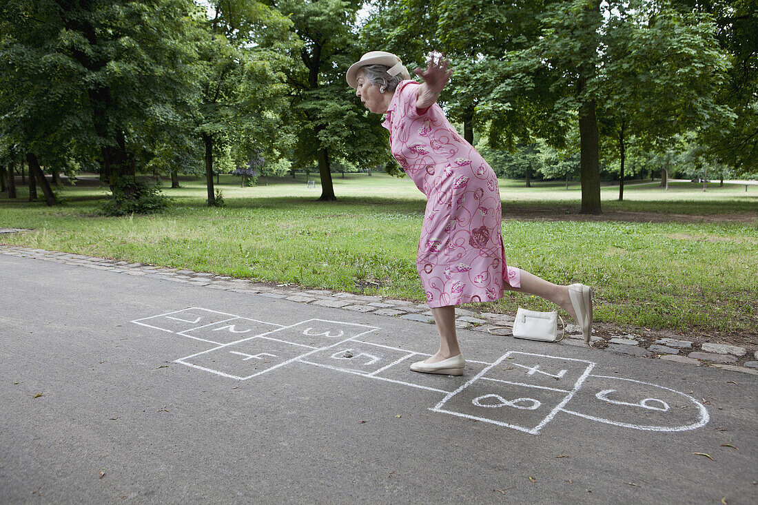 Senior woman playing hopscotch