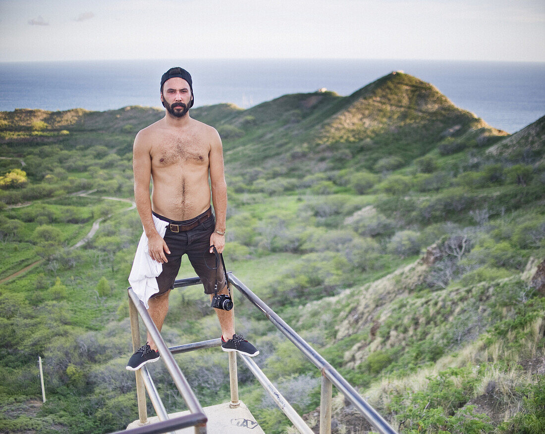 Portrait of shirtless man standing at observation point, Diamond Head Crater, Oahu, Hawaii, USA