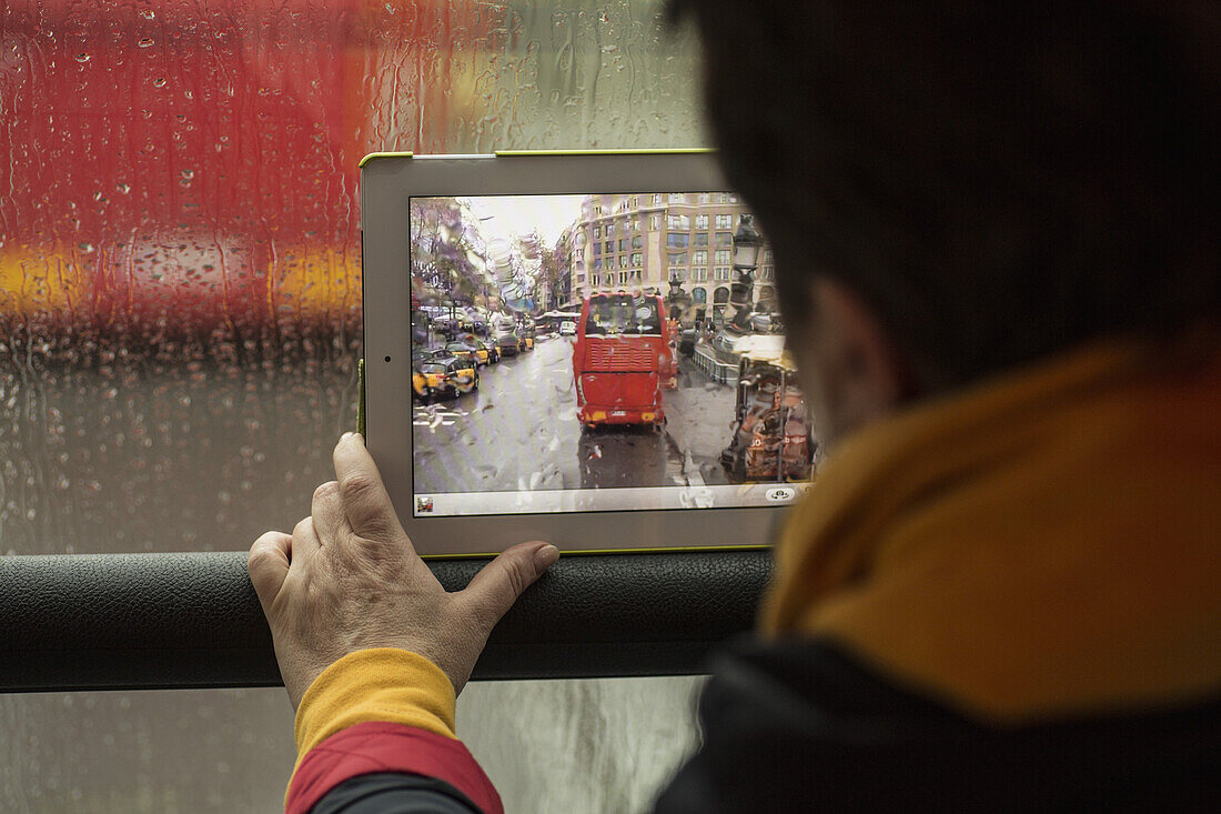 Rear view of woman photographing bus with digital tablet