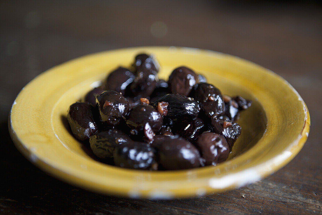 Close-up of marinated black olives in plate