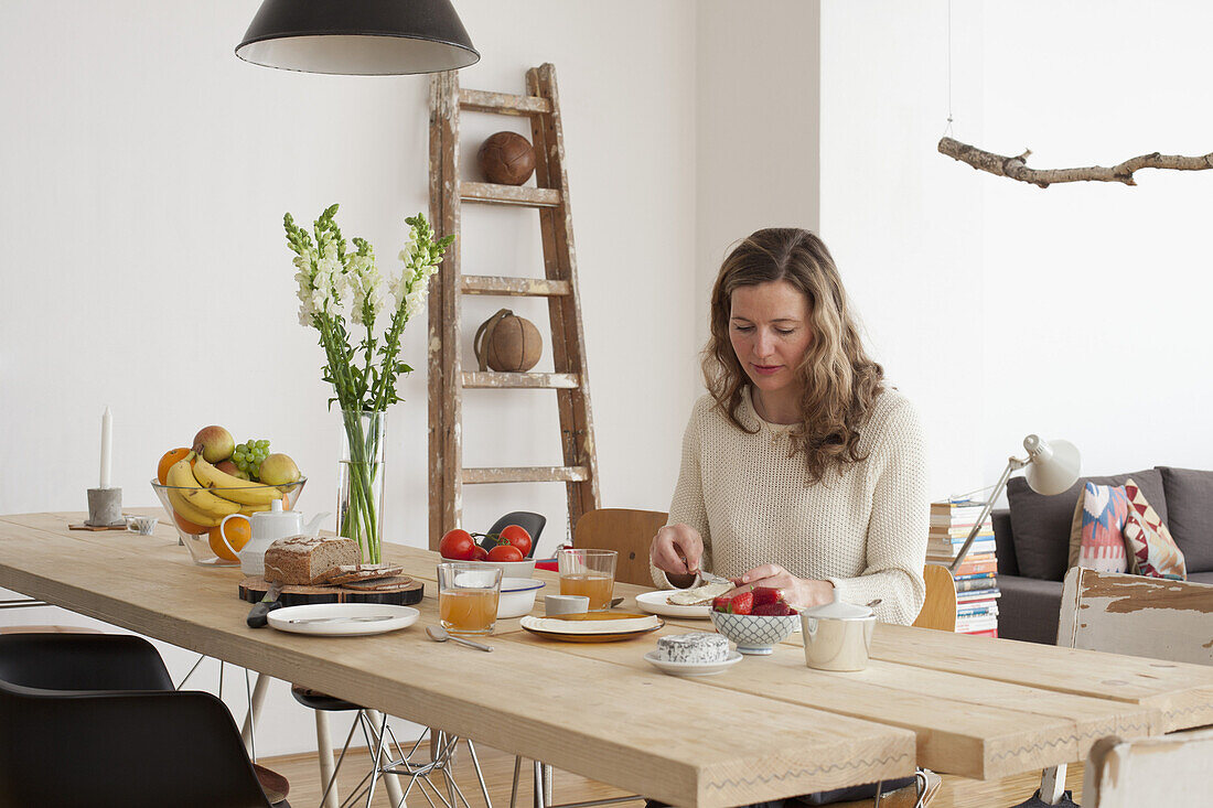 Mid adult woman having breakfast at table