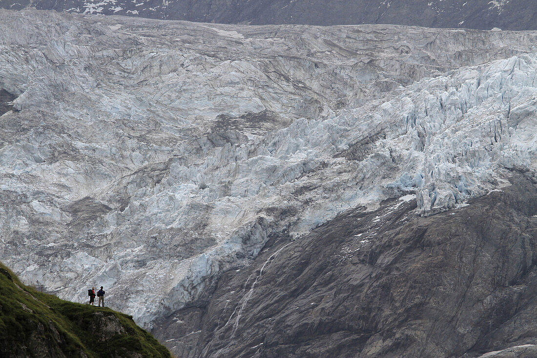 Two hikers looking at a glacier