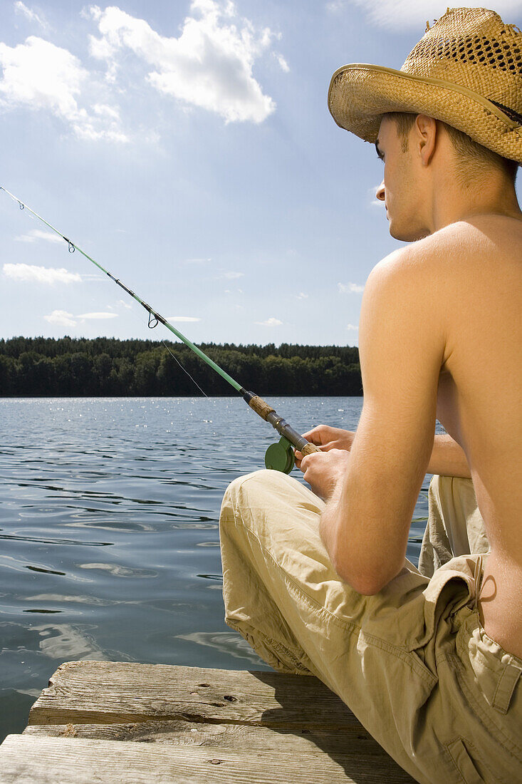 Young man fishing in lake