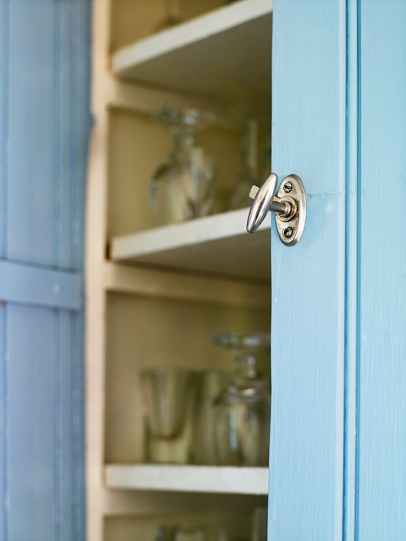 Metalltürgriff am blauen Schrank mit geöffneter Tür