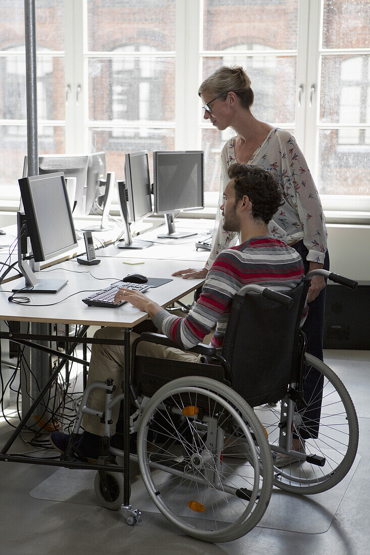 Man and woman working on computer in office