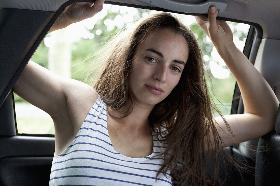 Portrait of young woman in car, close-up